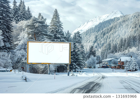 Blank billboard stands on a snowy roadside, surrounded by forested mountains. Concept of winter advertising. For mockup design. 131693966
