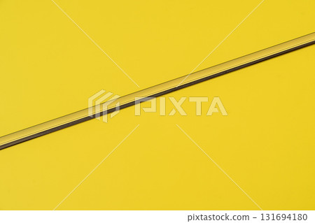 Description: Minimalist yellow background with diagonal metallic line, clean geometric composition. Concept of yellow, minimalism, design reflecting simplicity and balance, color of year, copy space 131694180