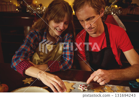 Couple Baking Christmas Cookies Together in a Festive Kitchen, Warm Family Moment 131694243