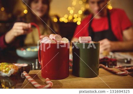 Cozy Christmas Kitchen Scene With Marshmallows On Hot Chocolate Mugs, Candy Canes, And Warm Lights Cozy Christmas Kitchen Scene With Marshmallows On Hot Chocolate Mugs, Candy Canes, And Warm Lights 131694325