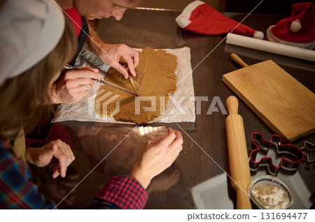 Family Baking Christmas Cookies: Cutting Gingerbread Dough Together With Rolling Pin And Cookie Cutters Family Baking Christmas Cookies: Cutting Gingerbread Dough Together With Rolling Pin And Cookie Cutters 131694477