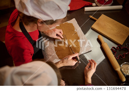 Family Baking Cookies: Hands Rolling Dough, Cutting Shapes With Cookie Cutters In Cozy Kitchen Family Baking Cookies: Hands Rolling Dough, Cutting Shapes With Cookie Cutters In Cozy Kitchen 131694478