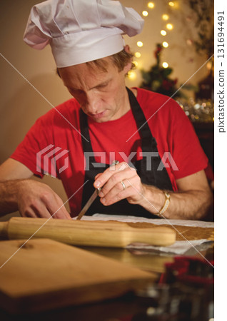 Chef In White Hat Preparing Dough With Knife In Cozy Holiday Kitchen 131694491