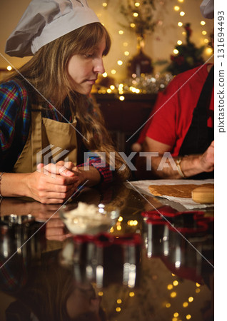 Chef In Hat And Apron Baking Cookies In Festive Kitchen With Christmas Lights Chef In Hat And Apron Baking Cookies In Festive Kitchen With Christmas Lights 131694493