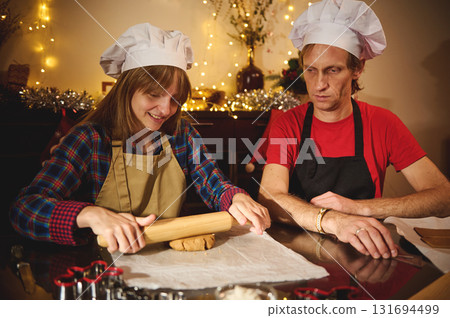 Family Bake Night With Two Chefs Rolling Dough for Christmas Cookies in a Cozy Kitchen Family Bake Night With Two Chefs Rolling Dough for Christmas Cookies in a Cozy Kitchen 131694499
