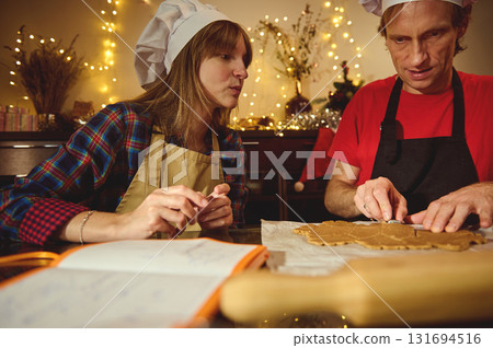 Two People in Chef Hats Craft Cookies in a Cozy Festive Kitchen 131694516