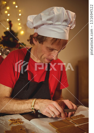 Chef at Work: Christmas Baking Scene with White Hat, Red Shirt, and Warm Fairy Lights in the Background Chef at Work: Christmas Baking Scene with White Hat, Red Shirt, and Warm Fairy Lights in the Background 131694522