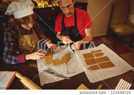 Family Baking Together: Two People Creating Gingerbread Cookies in a Festive Kitchen 131694524