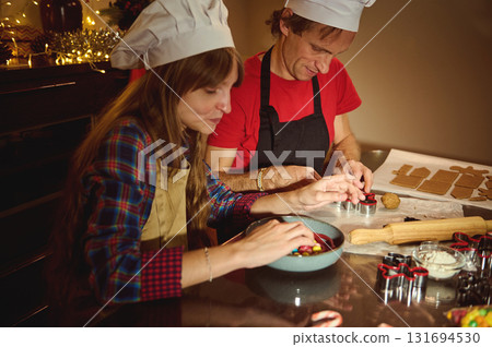 Family And Friends Baking Together: Chefs In Hats Cut Cookies, Decorate Treats, And Share Warm Christmas Kitchen Moments Family And Friends Baking Together: Chefs In Hats Cut Cookies, Decorate Treats, And Share Warm Christmas Kitchen Moments 131694530