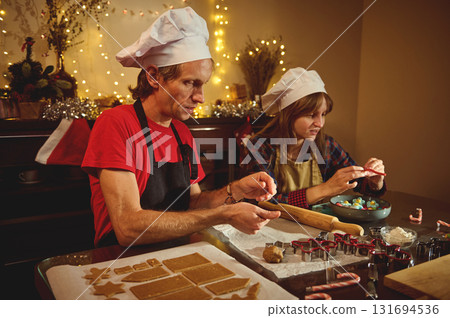 Two Chefs Cooking Christmas Cookies Together in a Cozy Kitchen with Warm Fairy Lights Two Chefs Cooking Christmas Cookies Together in a Cozy Kitchen with Warm Fairy Lights 131694536