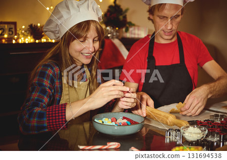 Family Christmas Baking: Couple in Aprons Craft Colorful Candy Treats Together in a Cozy Festive Kitchen Family Christmas Baking: Couple in Aprons Craft Colorful Candy Treats Together in a Cozy Festive Kitchen 131694538