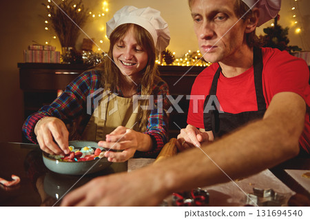 Family And Friends Bake Christmas Cookies In A Cozy Kitchen With Chef Hats, Warm Lights, And Holiday Joy Family And Friends Bake Christmas Cookies In A Cozy Kitchen With Chef Hats, Warm Lights, And Holiday Joy 131694540