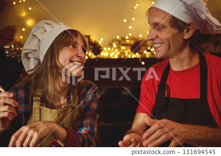 Joyful Cooks Share a Warm, Festive Moment in a Cozy Kitchen Joyful Cooks Share a Warm, Festive Moment in a Cozy Kitchen 131694545