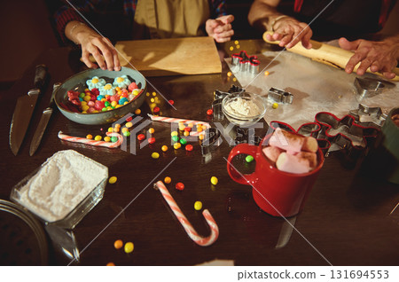 Family Christmas Baking Scene With Kids Rolling Dough, Candy, and Cookie Cutters on a Cozy Kitchen Table Family Christmas Baking Scene With Kids Rolling Dough, Candy, and Cookie Cutters on a Cozy Kitchen Table 131694553