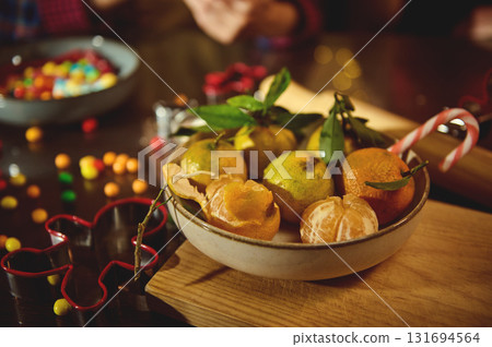 Fruit Bowl With Oranges, Lemons, And Candy Cane On Wooden Board For Festive Snack Moments Fruit Bowl With Oranges, Lemons, And Candy Cane On Wooden Board For Festive Snack Moments 131694564