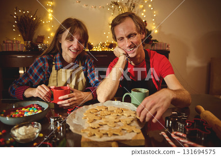 Couple Bakes Christmas Cookies At Home With Warm Lights, Holiday Cheer, And Shared Joy 131694575