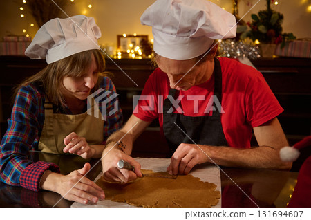Two Chefs Wearing White Hats Craft Gingerbread Dough In Cozy Holiday Kitchen Two Chefs Wearing White Hats Craft Gingerbread Dough In Cozy Holiday Kitchen 131694607
