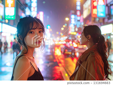 電影般的畫面：夜晚霓虹閃爍的城市中，兩名女子被雨水浸透 131694663