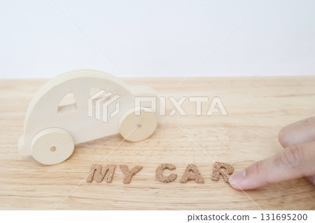Wooden car toy and my car character. White background with copy space. Wooden car toy and my car character. White background with copy space. 131695200