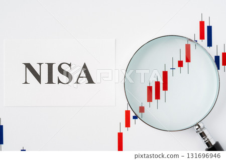 The word NISA and a magnifying glass on a candlestick chart on a white background 131696946