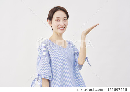 Woman, middle-aged, palm pointing to the right, white background Woman, middle-aged, palm pointing to the right, white background 131697316