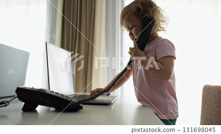Preschooler girl picks up landline phone and pretends to talk Preschooler girl picks up landline phone and pretends to talk 131698045
