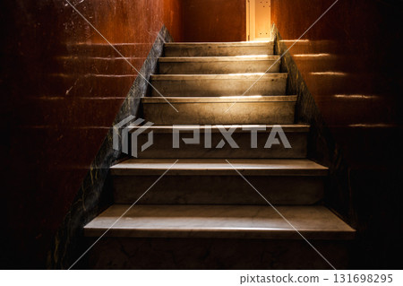 Sunlit marble staircase in an old Roman building with reflections on polished brown walls and soft contrast of light and shade Sunlit marble staircase in an old Roman building with reflections on polished brown walls and soft contrast of light and shade 131698295