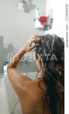 A person is washing their hair in a relaxing shower while using rich foam for cleaning 131698393