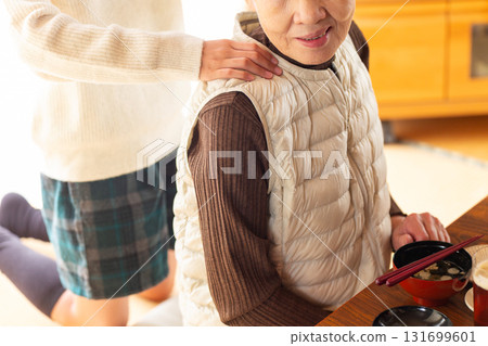 Granddaughter massaging grandma's shoulders Granddaughter massaging grandma's shoulders 131699601