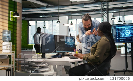 Joyous colleagues having fun during job shift break, doing bonding, concept of positive office culture. Workplace friends having playful discussion while using AI to optimize code, camera A 131700066