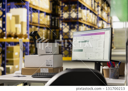 Empty distribution hub with big industrial storage racks filled with packages for large scale e-commerce operations. Space designed for fast delivery, product packaging and order processing. 131700213