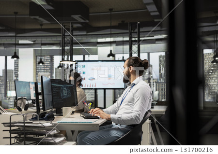 Male IT specialist uses AI neural networks for data sharing and digitalization, working in a multinational company with automation tools. Artificial intelligence models for business success. 131700216