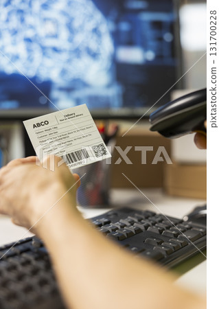 Close up of employee uses AI brain automation and scan shipping labels, registering barcodes with artificial intelligence automation to fulfill e-commerce operations. AI support. 131700228