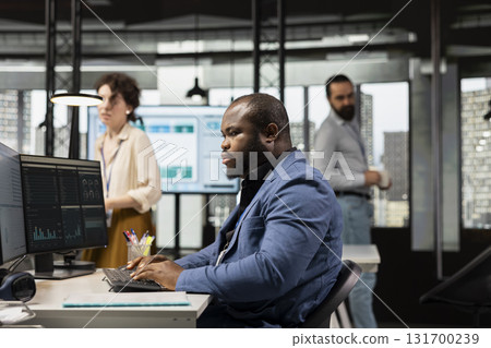 Black manager uses digital technology to forecast business performance in a multinational company office, creating strategy reports leveraging data insights to optimize management efficiency. 131700239