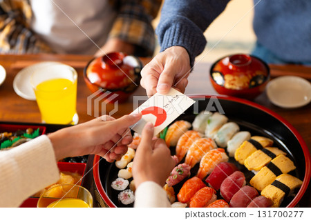 A child's hand receiving a New Year's gift from his father at his parents' house during the New Year holidays A child's hand receiving a New Year's gift from his father at his parents' house during the New Year holidays 131700277