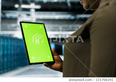 Close up of data center admin using isolated screen tablet to install equipment used for hosting digital services. Server hub worker repairs mainframes managing file transfers using chroma key device 131700291
