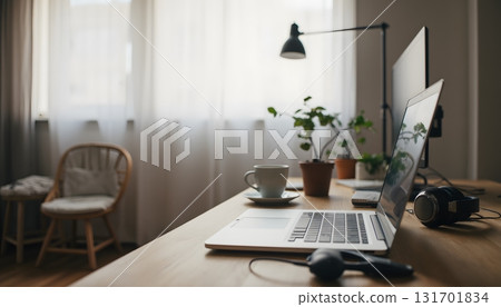 Cozy Home Office Workspace with Laptop, Plant, and Coffee Cup Beside Natural Light Window 131701834