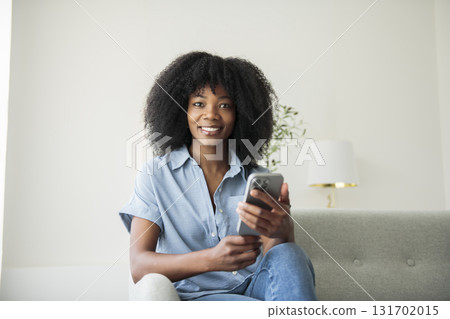 business woman on sofa and using cellphone 131702015