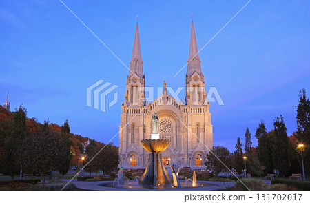 Sainte Anne de Beaupre Cathedral illuminated at dusk in autumn with beautiful leaves color and fountain on the foreground, Quebec, Canada Sainte Anne de Beaupre Cathedral illuminated at dusk in autumn with beautiful leaves color and fountain on the foreground, Quebec, Canada 131702017