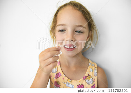 Smiling little girl missing tooth on white background 131702201