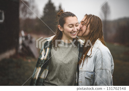 Lesbian Couple Together Outdoors in a rainy day Lesbian Couple Together Outdoors in a rainy day 131702548