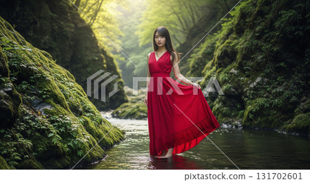 一位穿著紅色洋裝的女子走進清澈的小溪，溪水清澈，綠樹成蔭 131702601