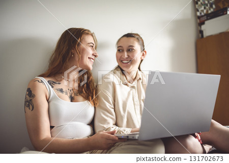 nice tattoo young girl sit on bed at home with laptop nice tattoo young girl sit on bed at home with laptop 131702673