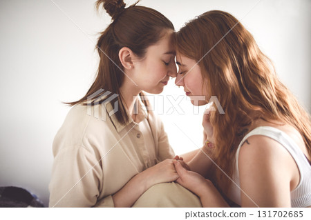 Happy couple cuddling on their bed at home. Romantic young LGBTQ 131702685