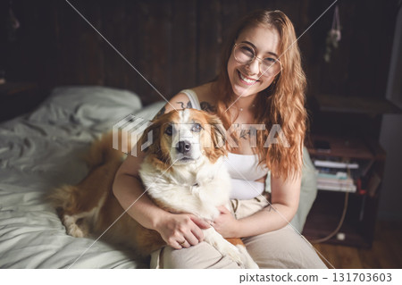 Woman having great time with dog on bed Woman having great time with dog on bed 131703603