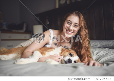 Woman having great time with dog on bed Woman having great time with dog on bed 131703628