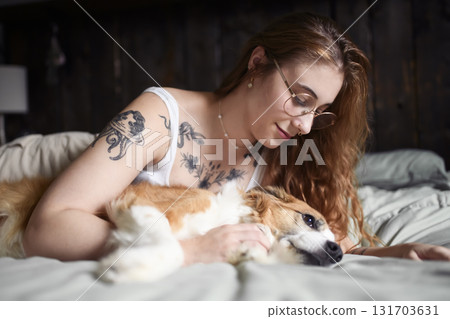 Woman having great time with dog on bed 131703631