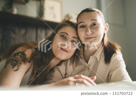 Happy couple cuddling on their bed at home. Romantic young LGBTQ 131703722