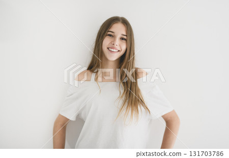 Portrait of teenage girl in casual t-shirt on light background in studio. 131703786