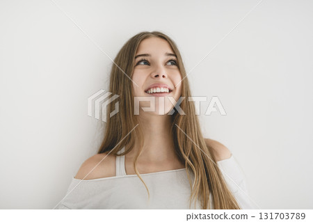 Portrait of teenage girl in casual t-shirt on light background in studio. Portrait of teenage girl in casual t-shirt on light background in studio. 131703789